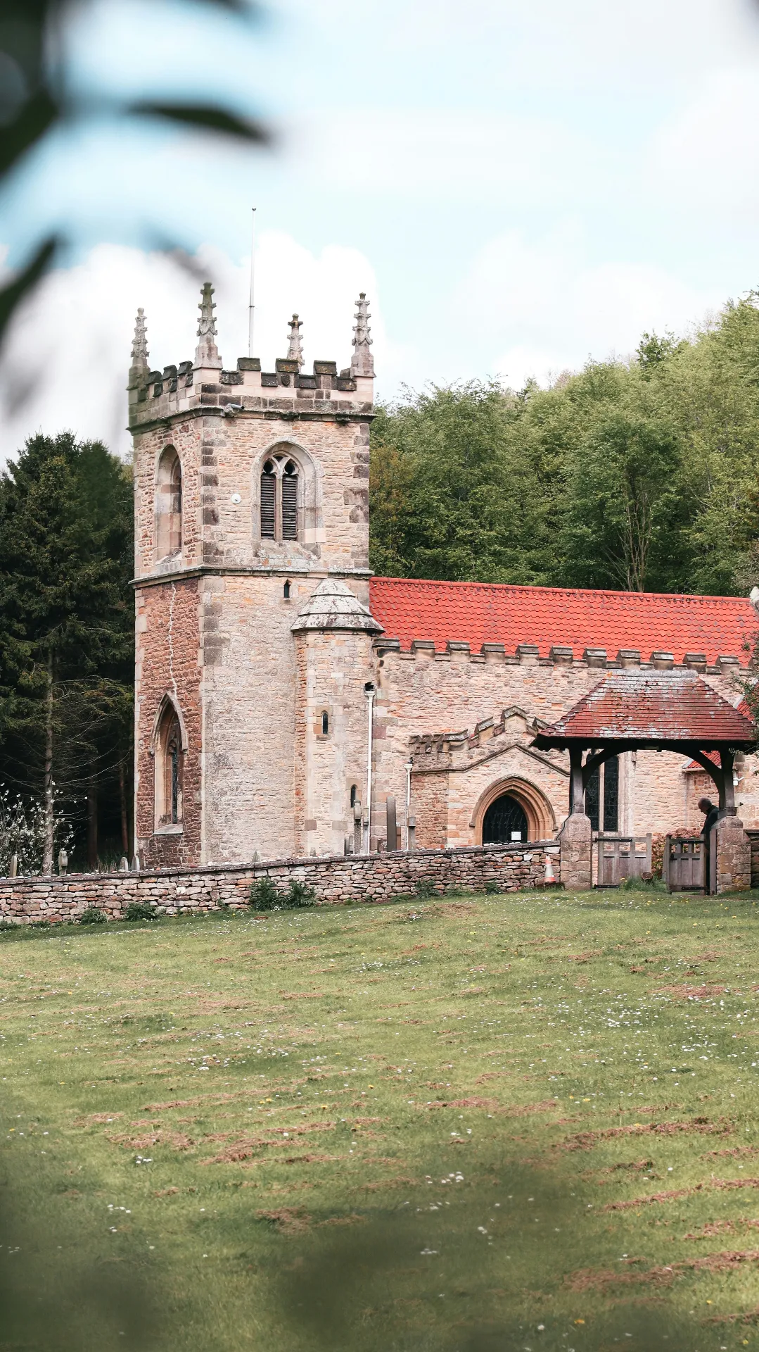 Stone parish church with tower and red tiled roof