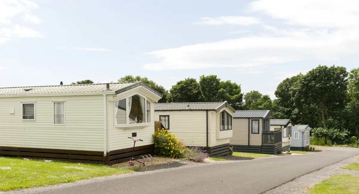 Holiday park clubhouse exterior with surrounding caravans