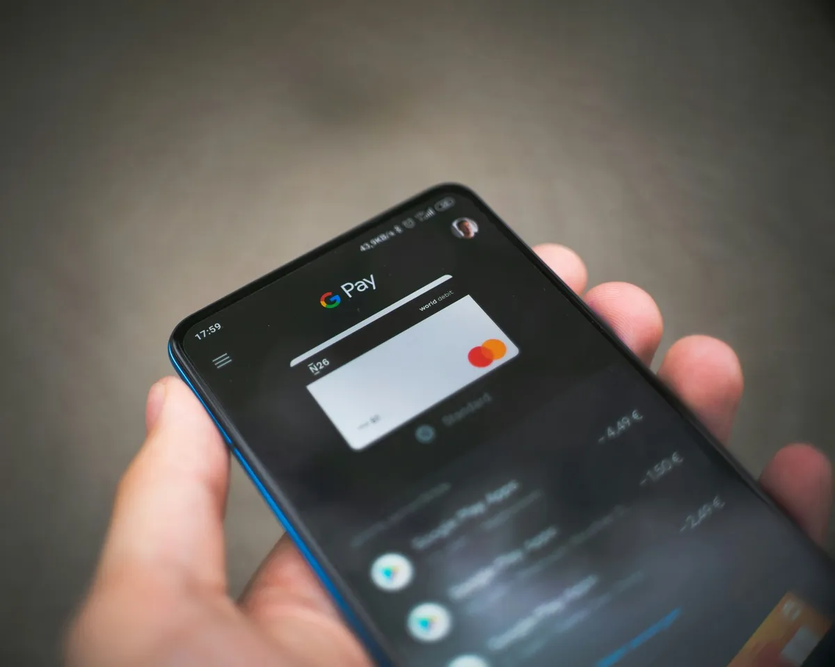 Customer paying at an outdoor event with Google Pay on a smartphone
