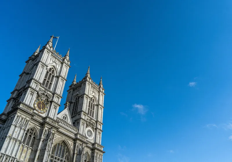 Grand church facade with twin towers against a clear blue sky